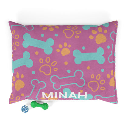 Personalized pink pet bed with bone patterns, soft fabric, and custom name embroidery for dogs or cats.
