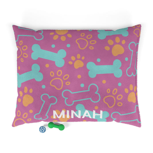 Pink personalized pet bed with bone pattern, soft fabric, designed for small dogs or cats, by Printify.