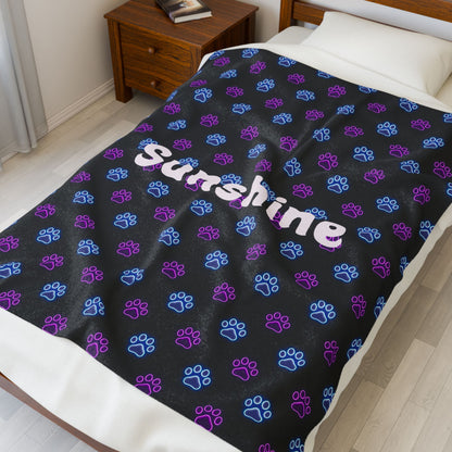 Soft personalized plush blanket with all-over neon paw print design, perfect for cozy comfort and custom gift-giving.